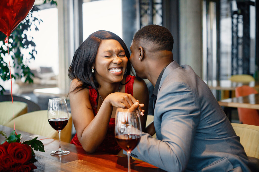 Romantic black couple sitting at restaurant wearing elegant clot